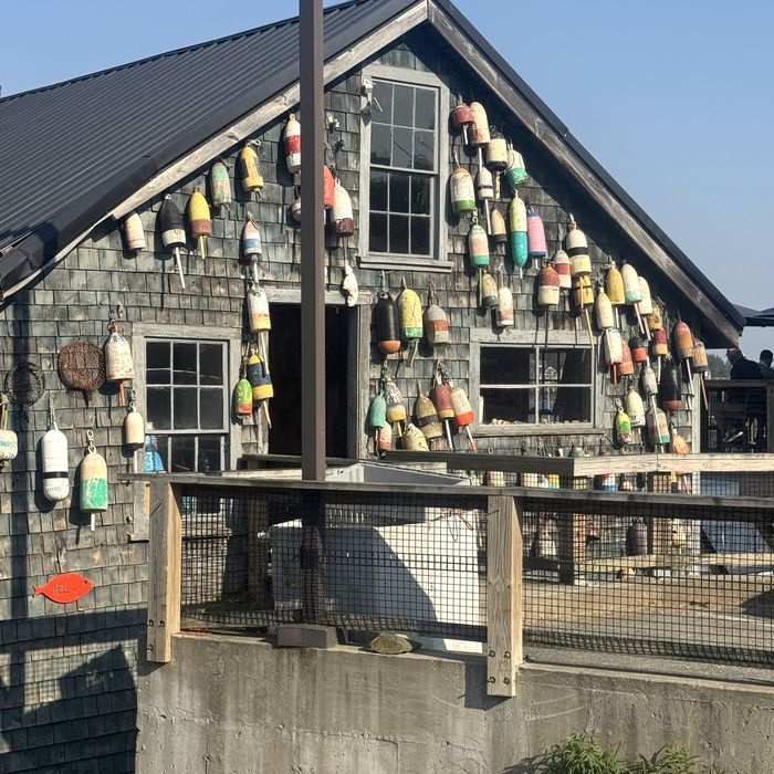 Lobster buoys hanging on a shingled fish house